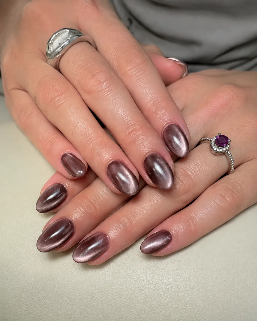 KI-bearbeitete Aufnahme: braune Chrome-Nägel und silberne Ringe